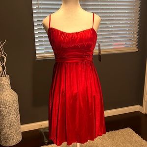 - Red satin lined strapless mini. Flowy bottom with adjustable straps.